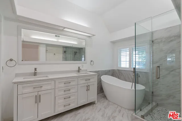 a spacious bedroom with a bed a couch and a flat screen tv