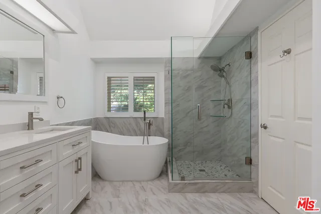 a kitchen with granite countertop white cabinets and window