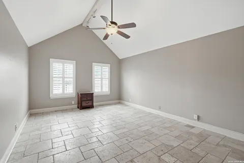 an empty room with windows and fan