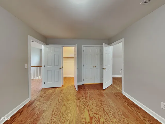 a view of empty room with wooden floor