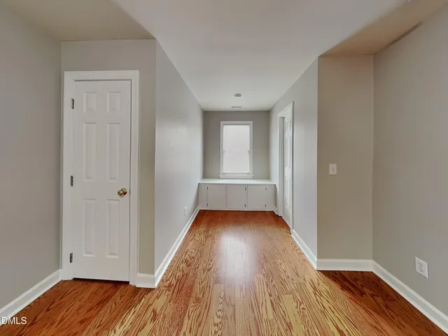 a view of a room with wooden floor and window