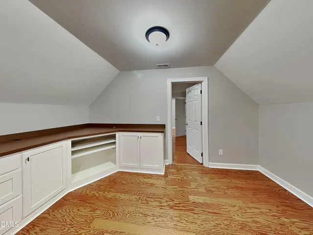 a view of an empty room with closet and entryway