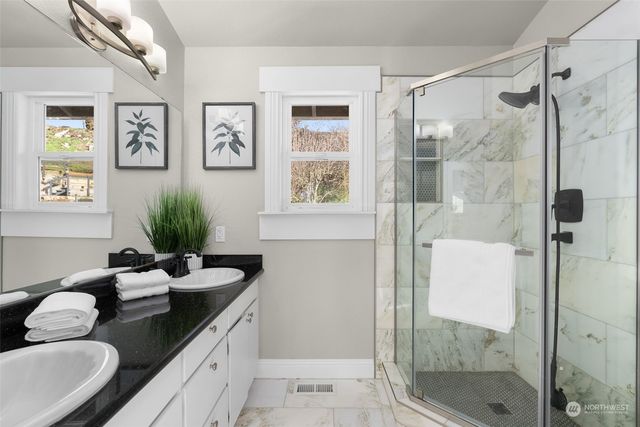 a bathroom with a granite countertop sink a shower and a mirror