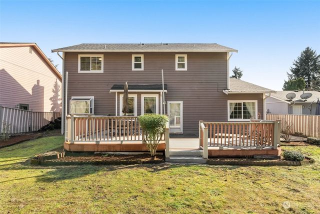 a view of a house with wooden fence and a yard