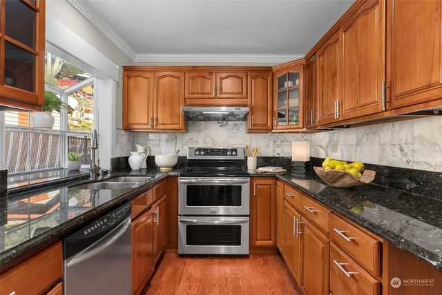 a kitchen with granite countertop stainless steel appliances and wooden cabinets