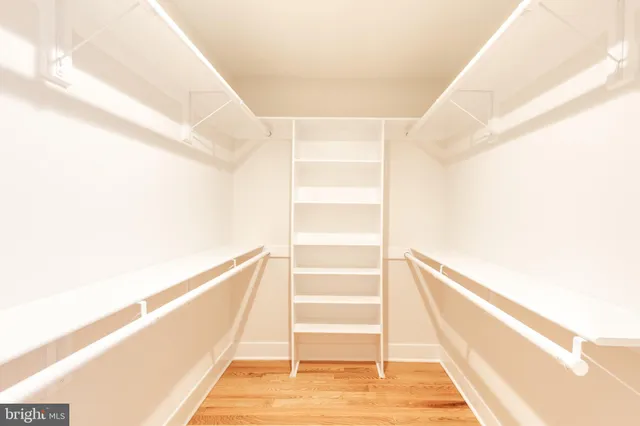 a view of staircase with white walls and a white door