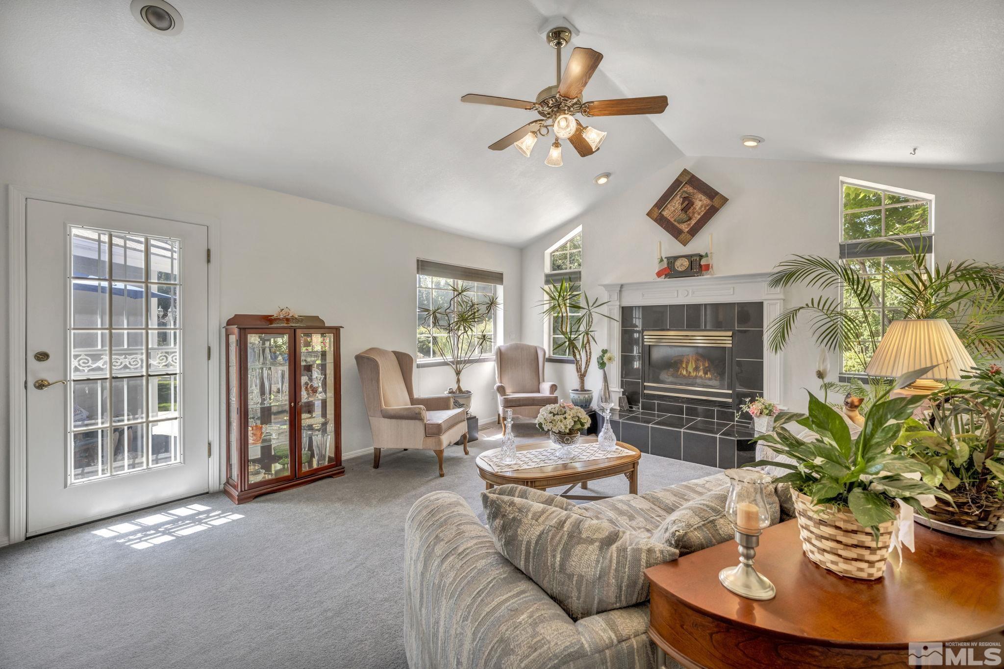 580 Holcomb Ranch Lane Reno, NV 89511 - Photo 27 of 40 a living room with furniture a chandelier and a fireplace
