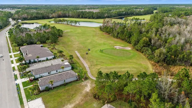 an aerial view of a houses with a yard and lake view