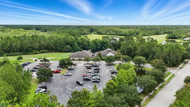 an aerial view of residential houses with outdoor space and trees all around