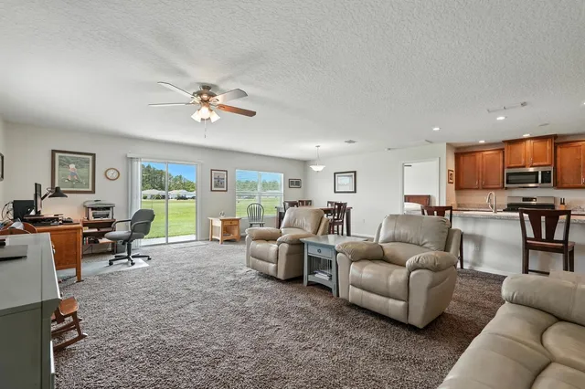 a living room with furniture ceiling fan and a window