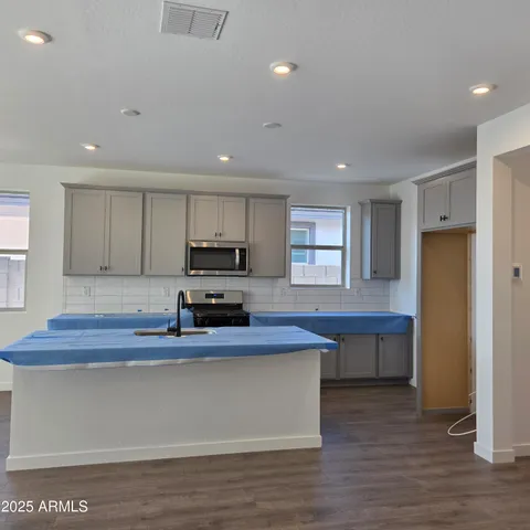 a kitchen with stainless steel appliances a sink cabinets and wooden floor