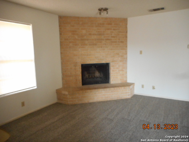 1036 Orts Drive, Unit B Pleasanton, TX 78064 - Photo 2 of 5 an empty room with a fireplace