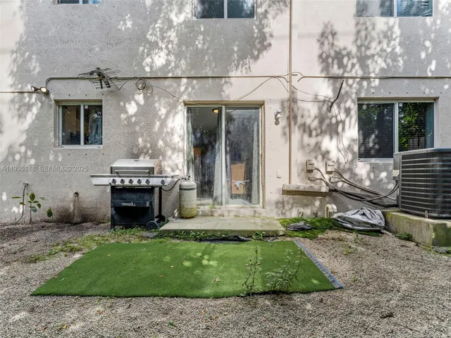 a view of a house with backyard fire pit and couches in the patio