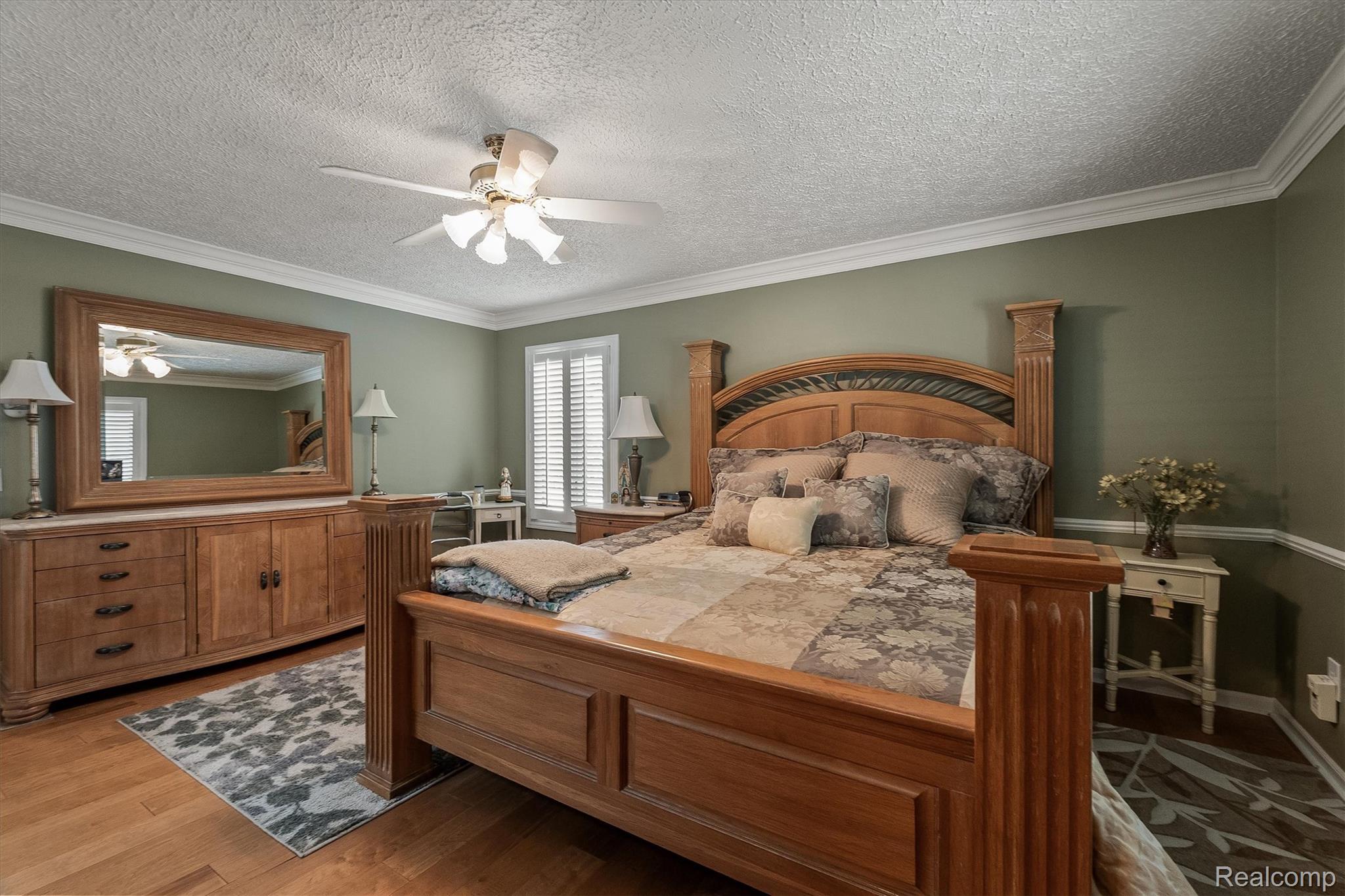 1662 Sumac Drive Rochester, MI 48309 - Photo 21 of 38 Spacious bedroom with wood-finish flooring, crown molding, and a ceiling fan