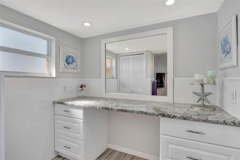 250 Bangsberg Road Southeast Port Charlotte, FL 33952 - Photo 18 of 59 a bathroom with a granite countertop sink and a mirror