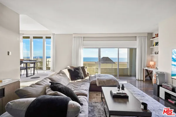 a living room with furniture and floor to ceiling windows