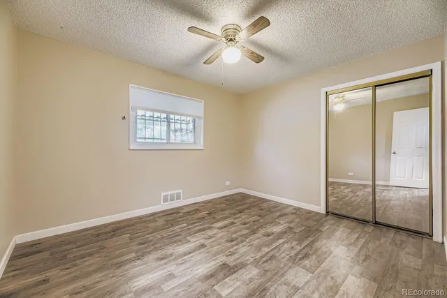 an empty room with fan and windows
