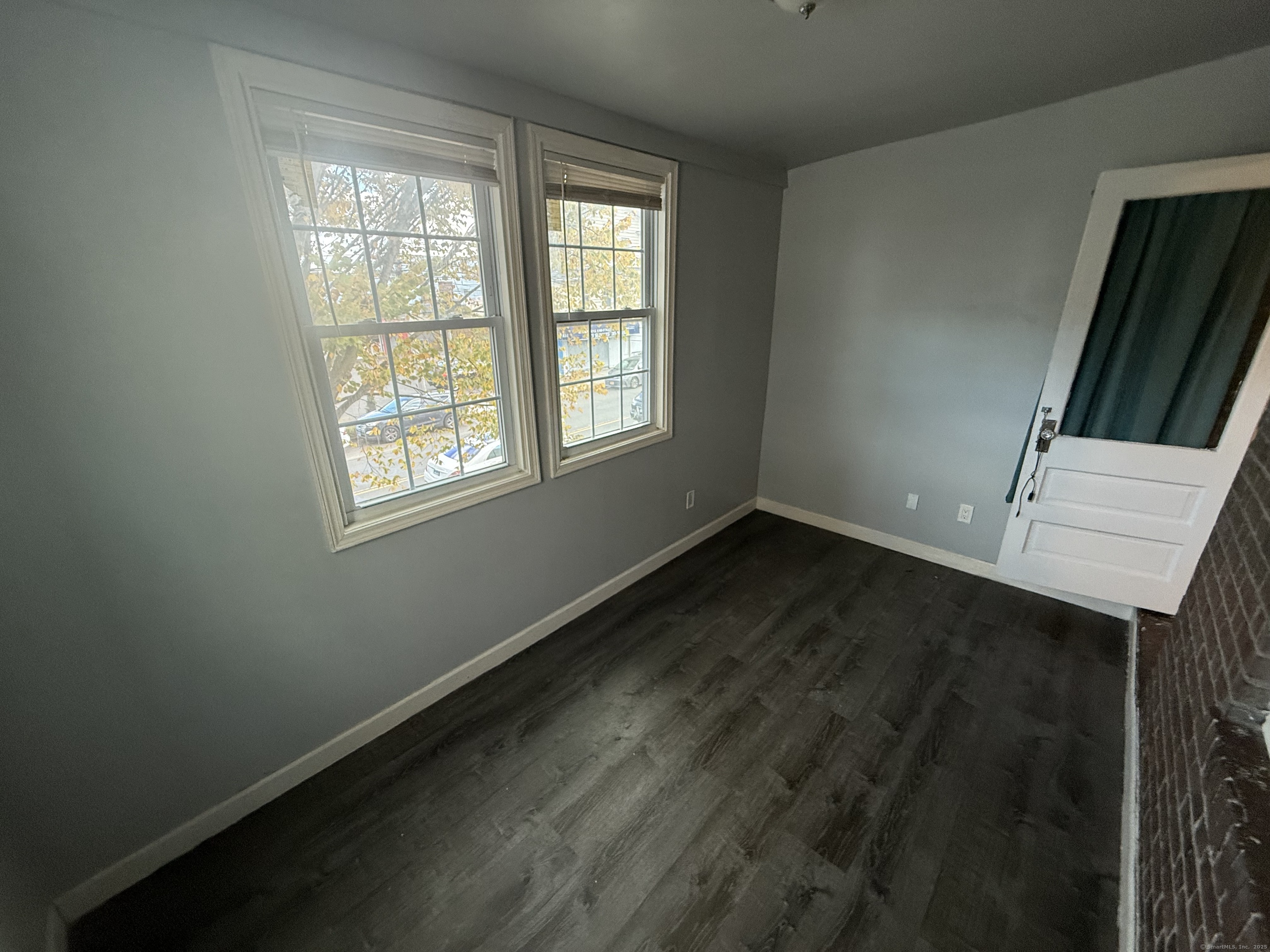 824 Capitol Avenue, Unit 2 Bridgeport, CT 06606 - Photo 5 of 9 an empty room with wooden floor and windows