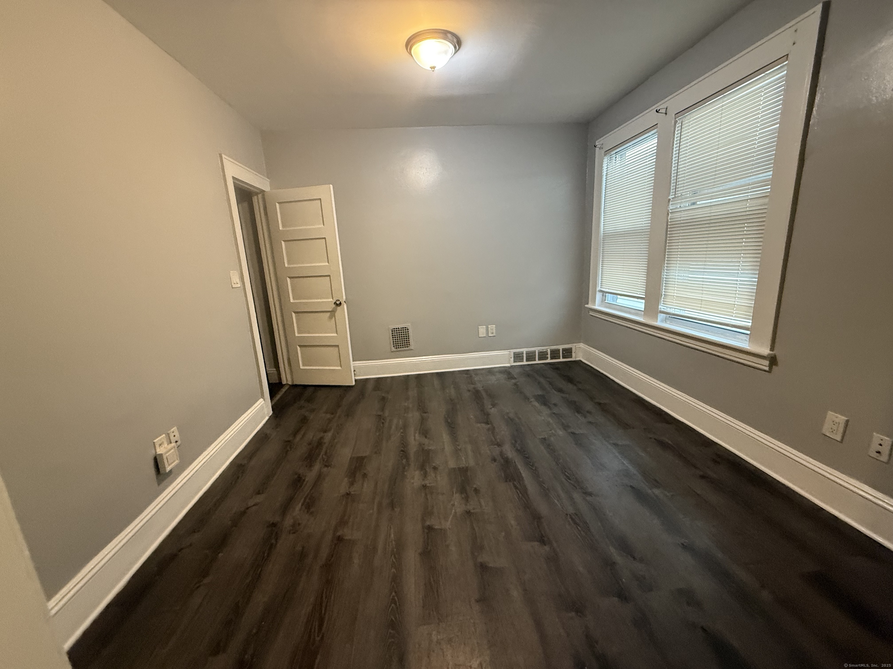 824 Capitol Avenue, Unit 2 Bridgeport, CT 06606 - Photo 6 of 9 an empty room with wooden floor and windows