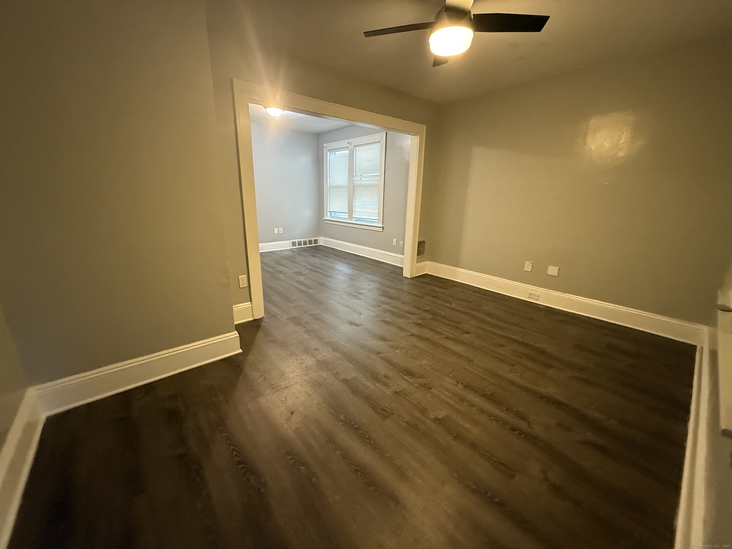 824 Capitol Avenue, Unit 2 Bridgeport, CT 06606 - Photo 8 of 9 an empty room with wooden floor and windows