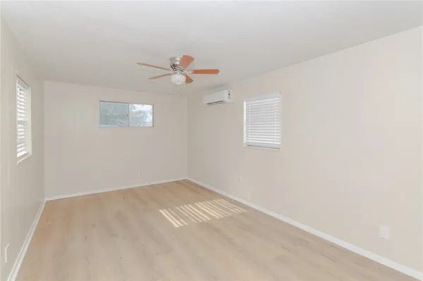 an empty room with a window and a fan