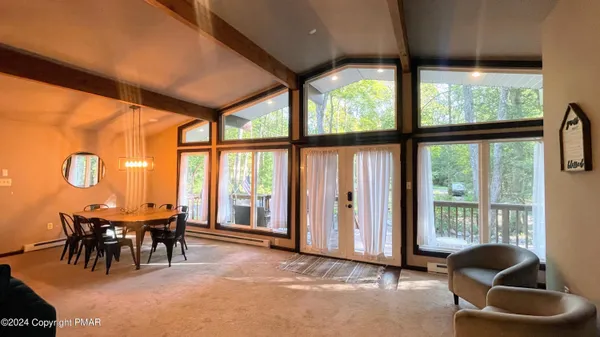 a dining room with furniture and a floor to ceiling window