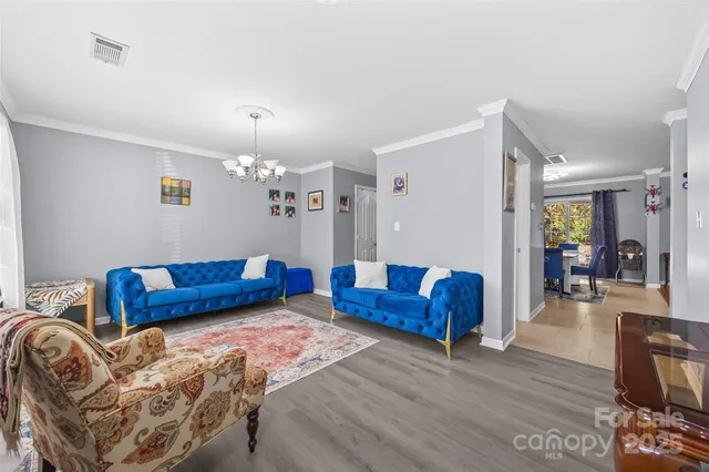 a living room with furniture and a chandelier