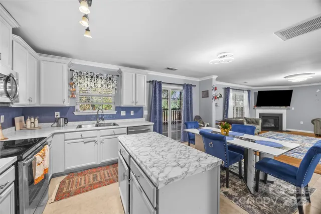 a kitchen with stainless steel appliances granite countertop a sink stove refrigerator and microwave