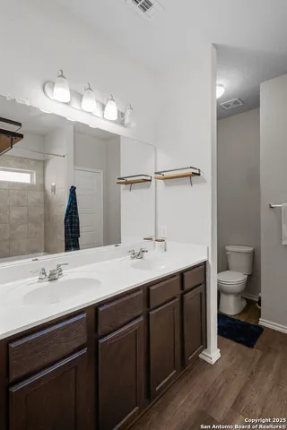 a bathroom with a double vanity sink and a toilet