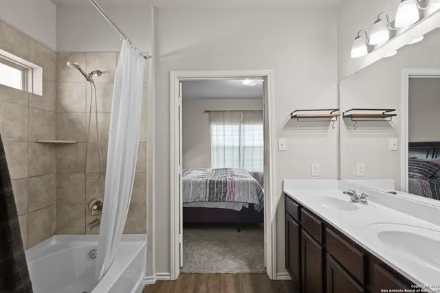 a en suite bathroom with a double vanity sink a mirror and a shower