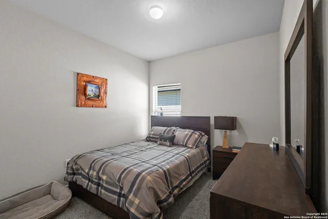 a bedroom with a bed and painting on the wall