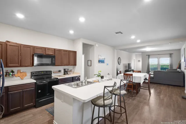 a kitchen with a sink a stove and chairs