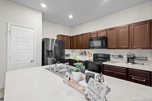 a kitchen with stainless steel appliances kitchen island granite countertop a refrigerator stove microwave and sink