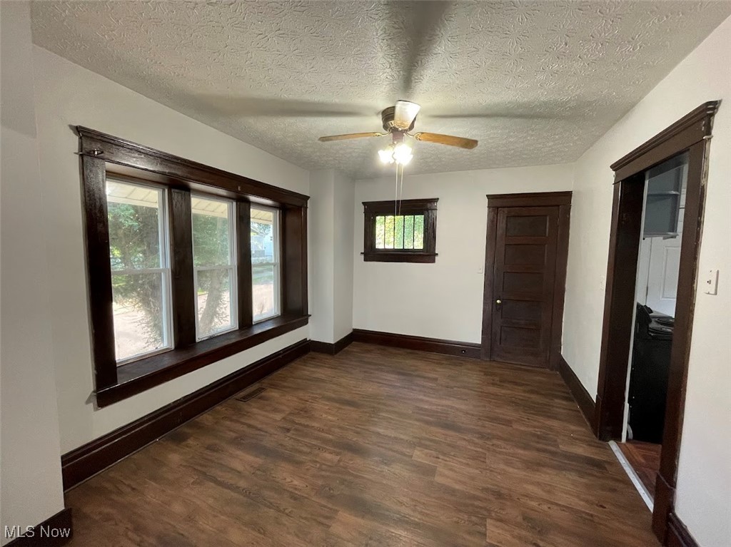 950 Avon Street Akron, OH 44310 - Photo 4 of 15 Spare room featuring a textured ceiling, dark wood-style flooring, and baseboards