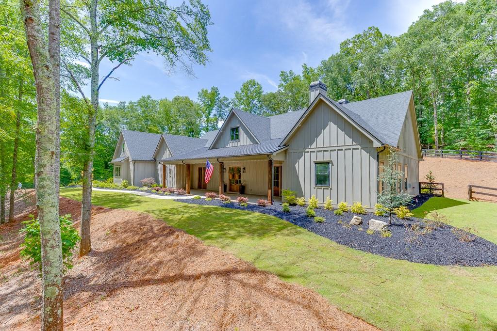 a front view of a house with a yard and trees