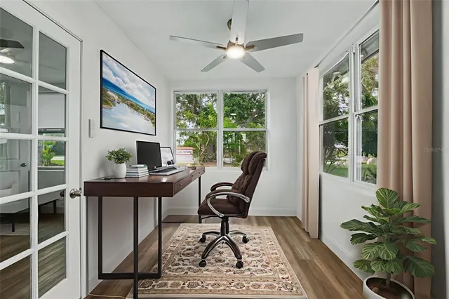 a view of a workspace with furniture and a window