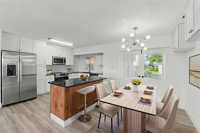 a kitchen that has a table chairs and stainless steel appliances