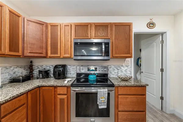 a kitchen with stainless steel appliances granite countertop a stove a microwave and cabinets