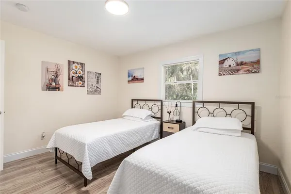 a bedroom with two beds and painting on the wall