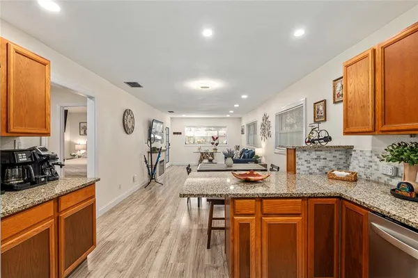 a kitchen with stainless steel appliances granite countertop sink stove refrigerator and cabinets