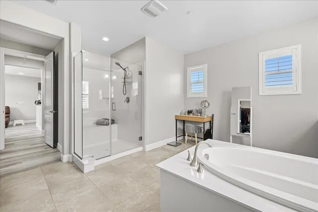 a bathroom with a tub a sink and shower
