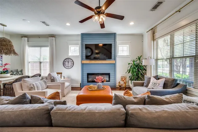 a living room with furniture a fireplace and a large window
