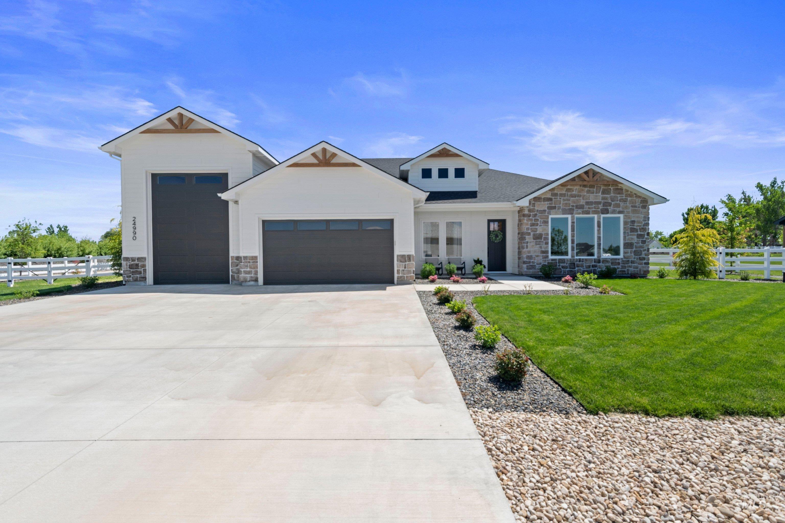 24990 Belgian Way Middleton, ID 83644 - Photo 2 of 50 Modern farmhouse exterior featuring stone accents, white siding, and a gabled roofline