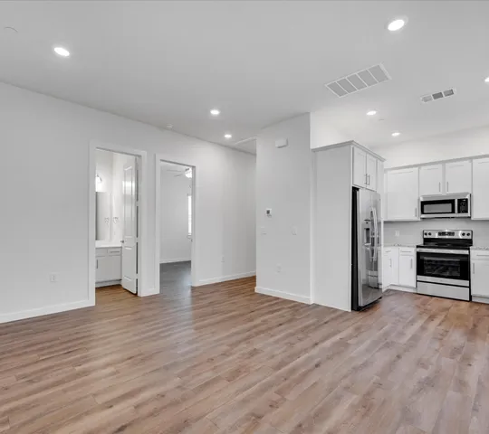 a view of a kitchen with stainless steel appliances a refrigerator and a stove