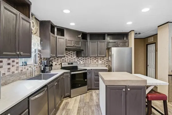 a kitchen with refrigerator cabinets and a sink