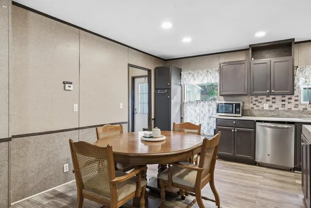 a kitchen with a dining table chairs and refrigerator