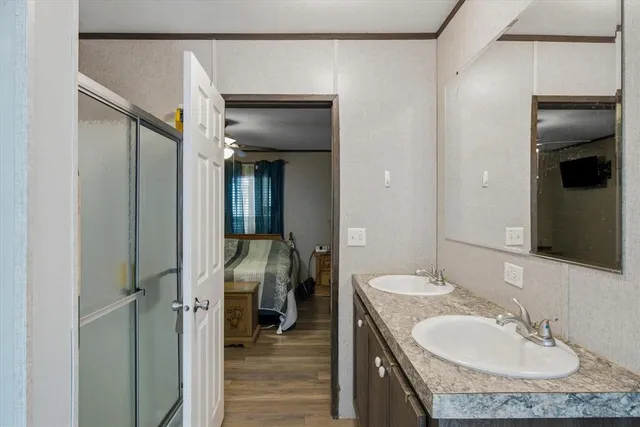 a en suite bathroom with a granite countertop sink and a mirror