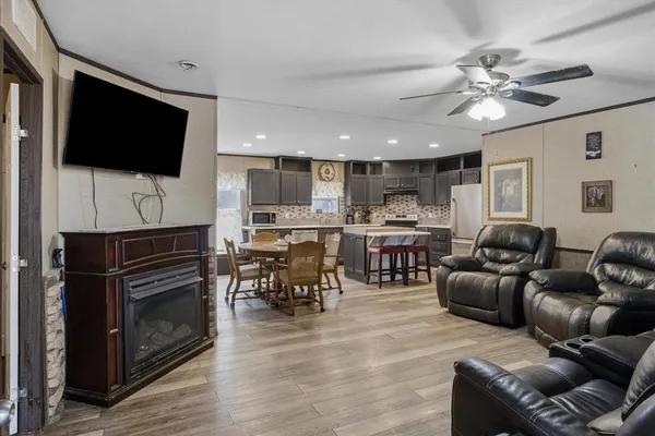 a living room with furniture a flat screen tv and kitchen view