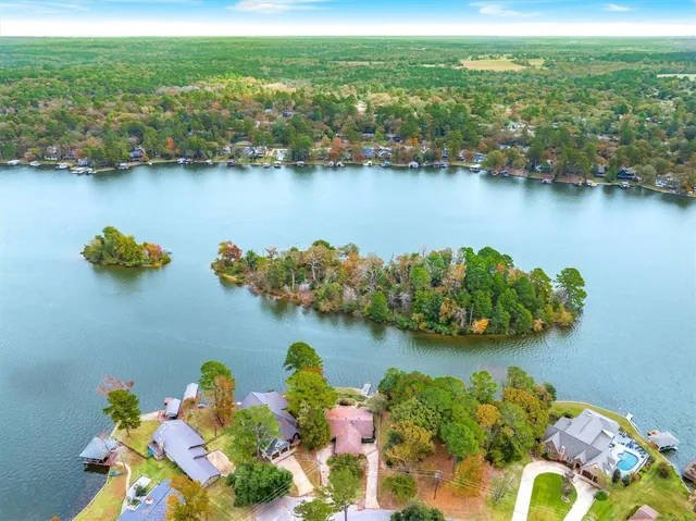 an aerial view of ocean and residential houses with outdoor space