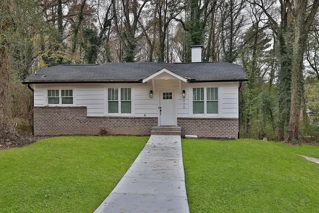 a front view of a house with yard and green space